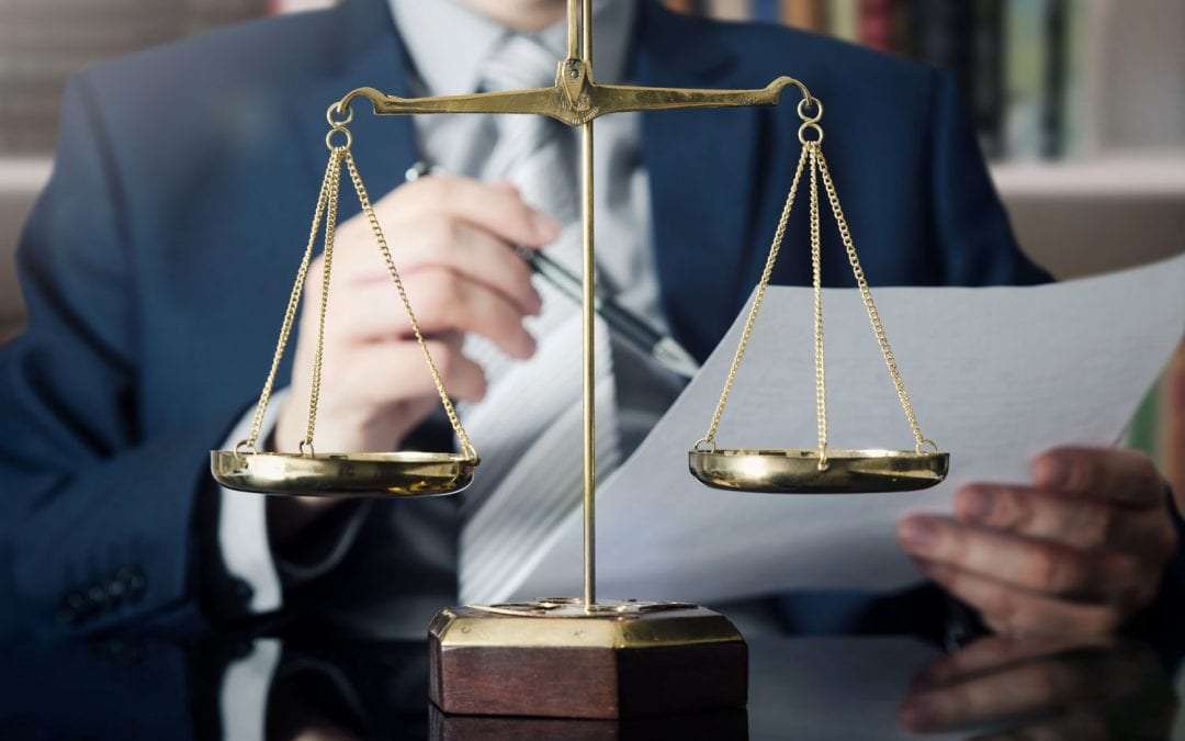 Attorney reviewing documents with brass scales