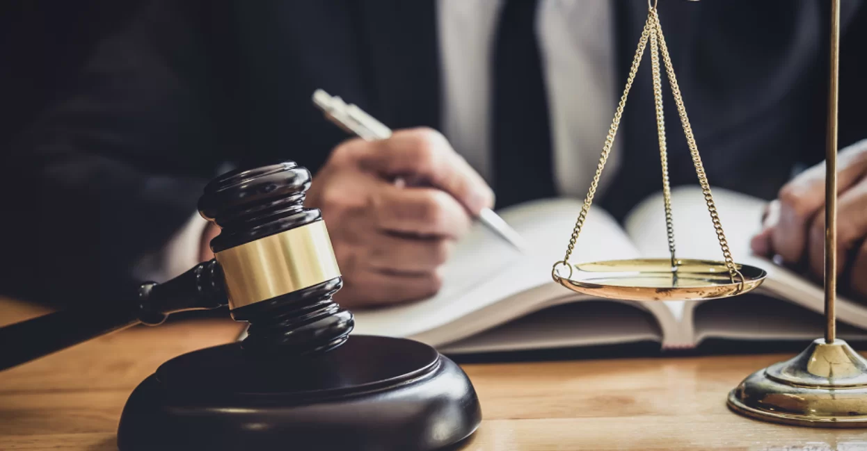 Gavel and scales while attorney writes